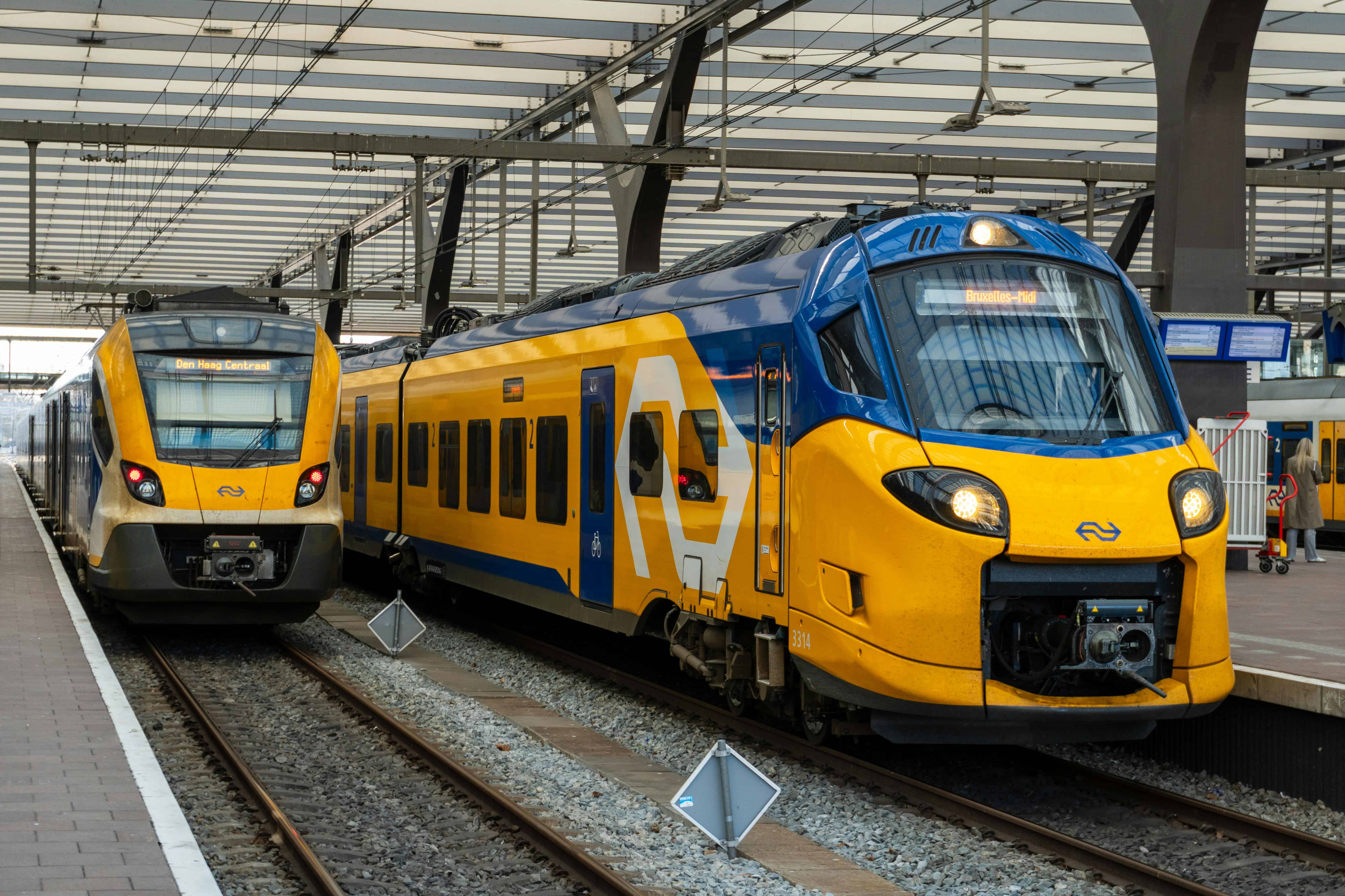 two-blue-and-yellow-ns-trains-rolling-into-rotterdam-centraal-station-in-the-netherlands